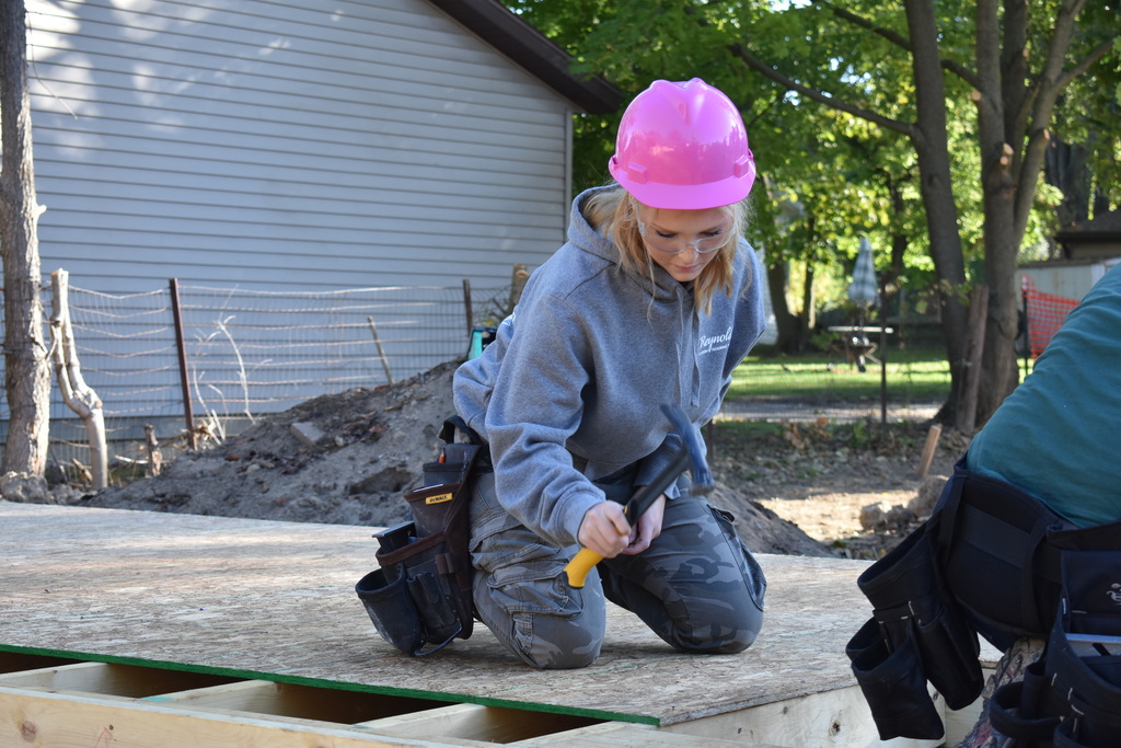 a student hammering in a nail