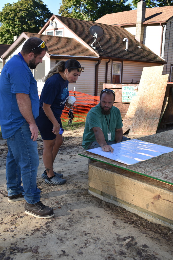 instructors showing the homeowner the blueprints for the first time