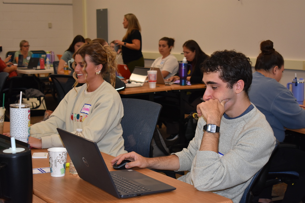 Educators at tables on their laptops