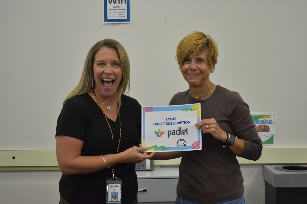 Ann Smart handing a certificate to a teacher who won a prize