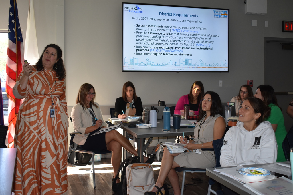 Presenter with LISD Literacy team in the background listening