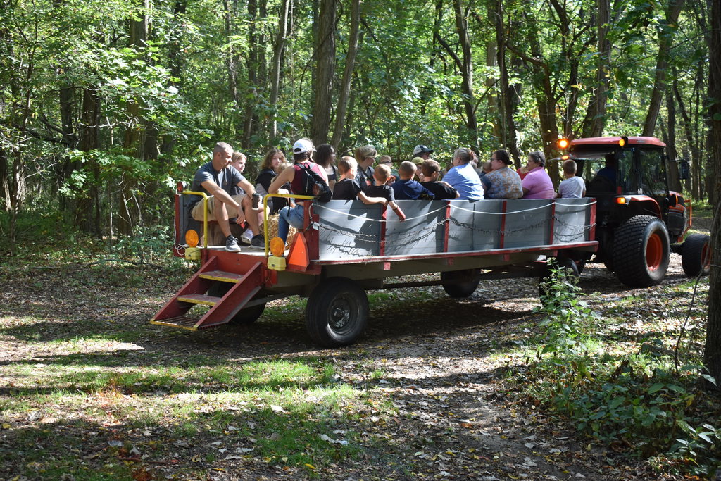 People enjoying a hay ride in the woods