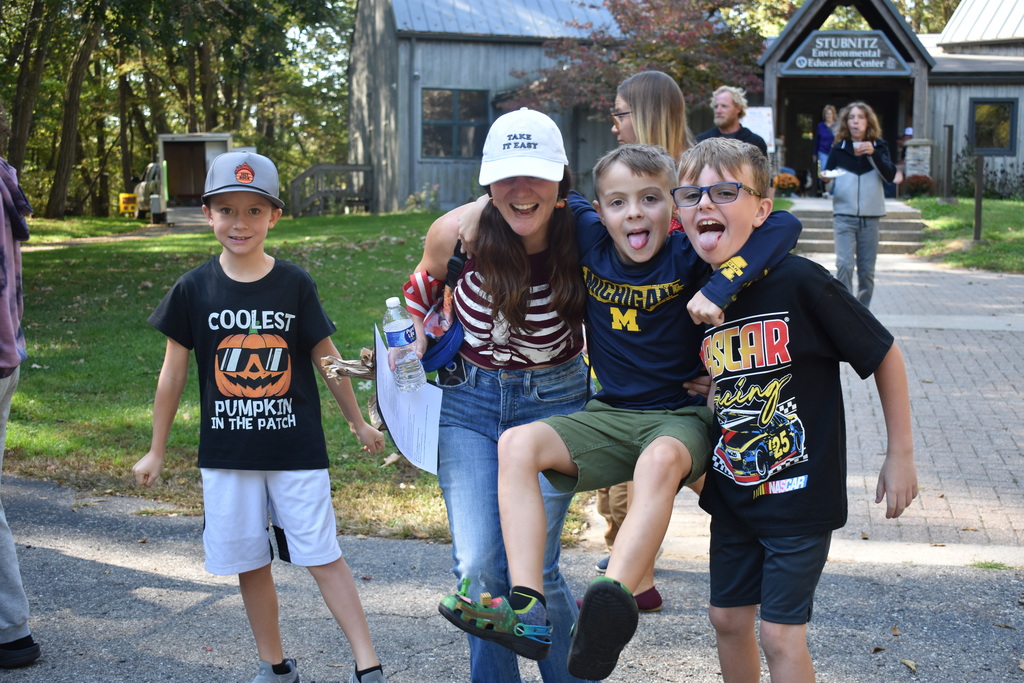 young kids and a mom smiling at the camera