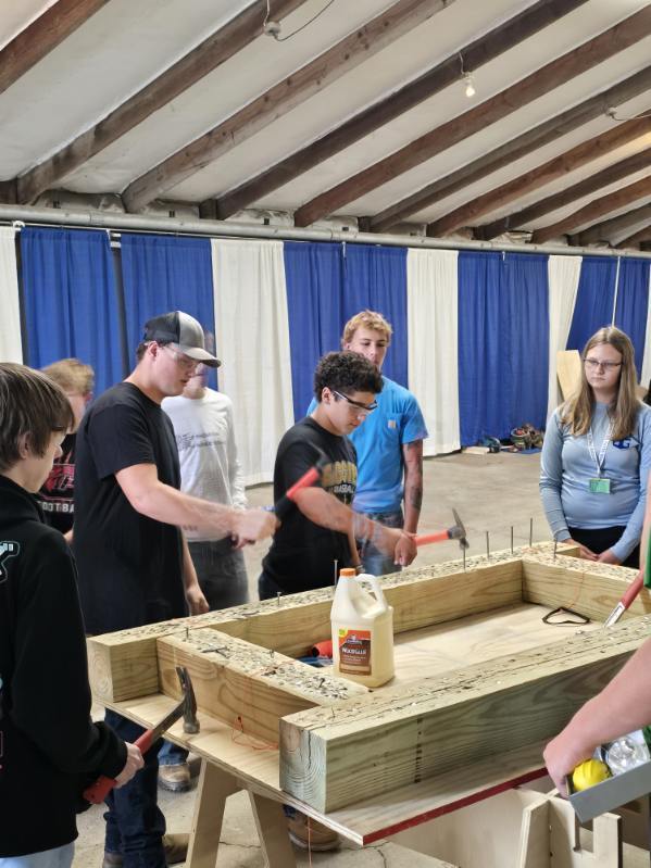 Students getting experience with hammers and nails in a demonstration