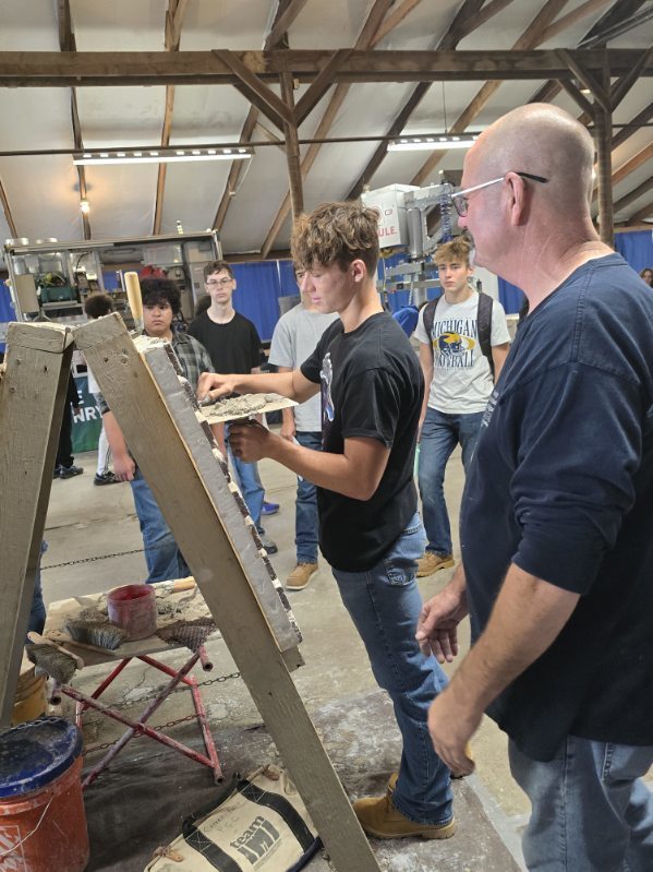 A student getting a real world experience of brick laying