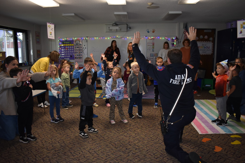 Students following a firefighters instructions to get read to stop, drop and roll