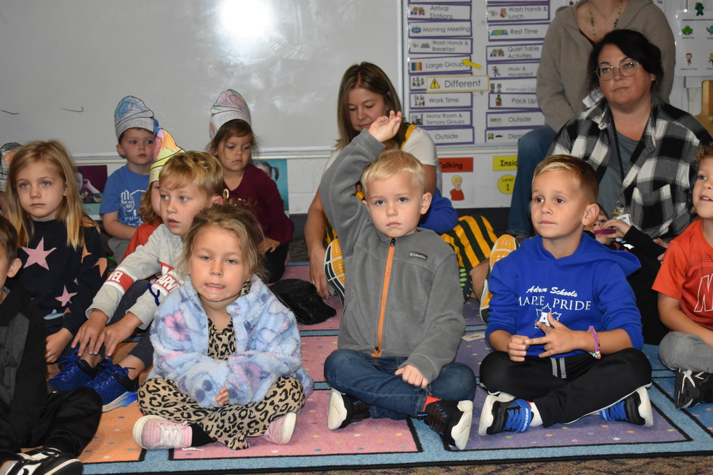A student raising his hand to answer a question