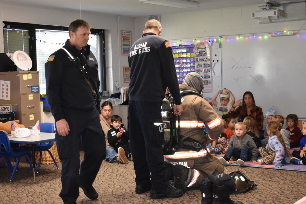 Students learning what a firefighter looks and sounds like with equipment on 