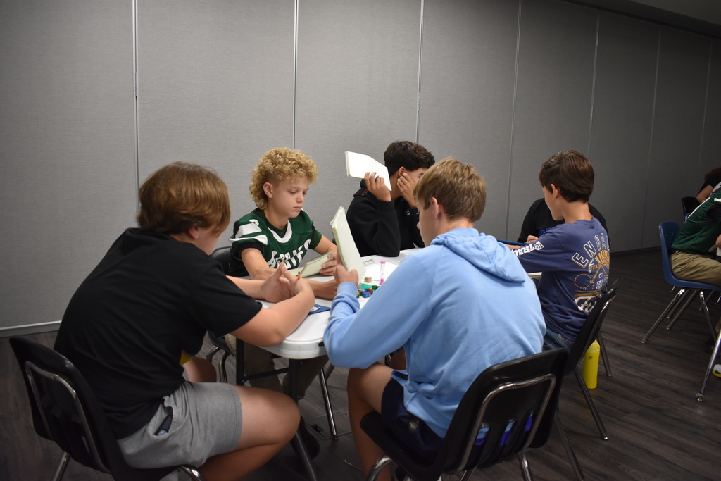 Students are competing around a table