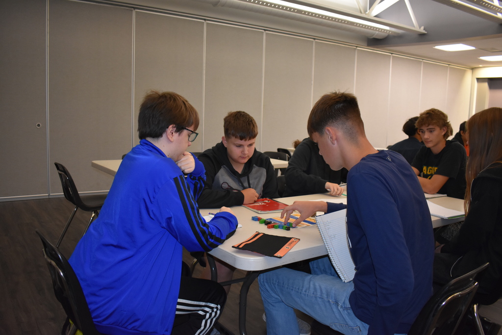 Three students intently think about their next move