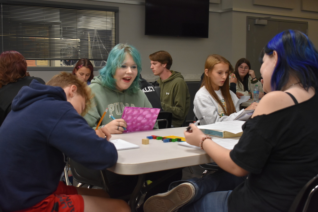 A student chuckles about the move she made while her opponent begins to consider their move