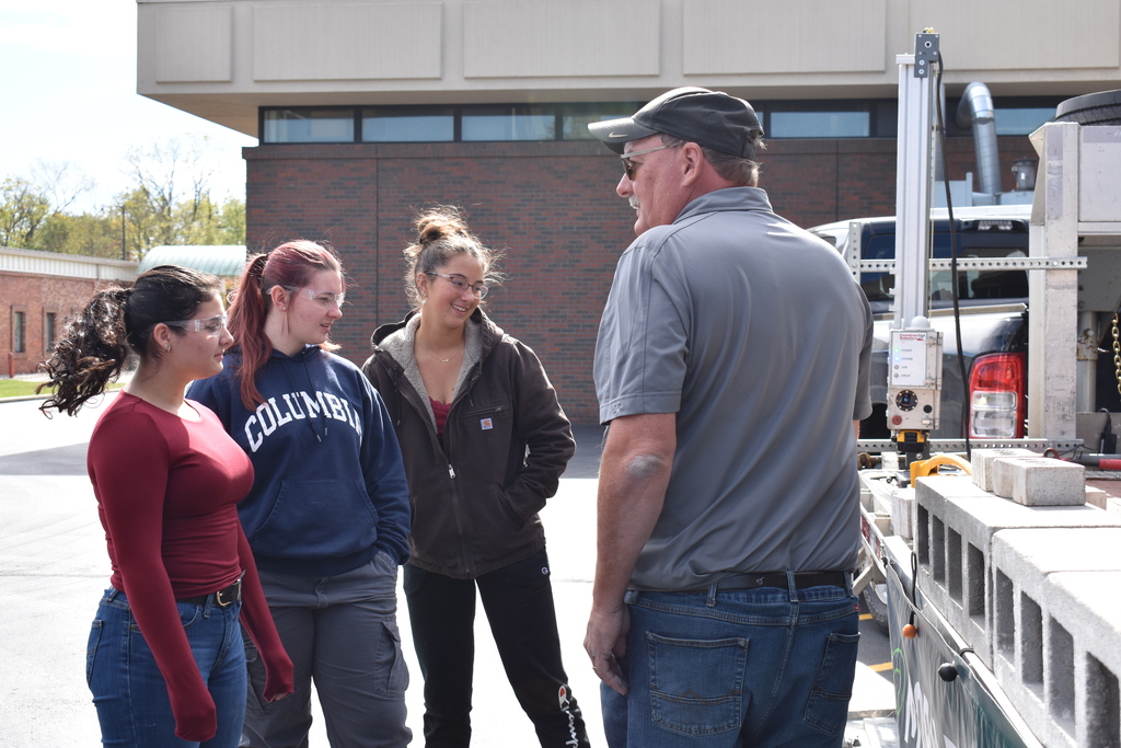 Three students listen to the demonstration