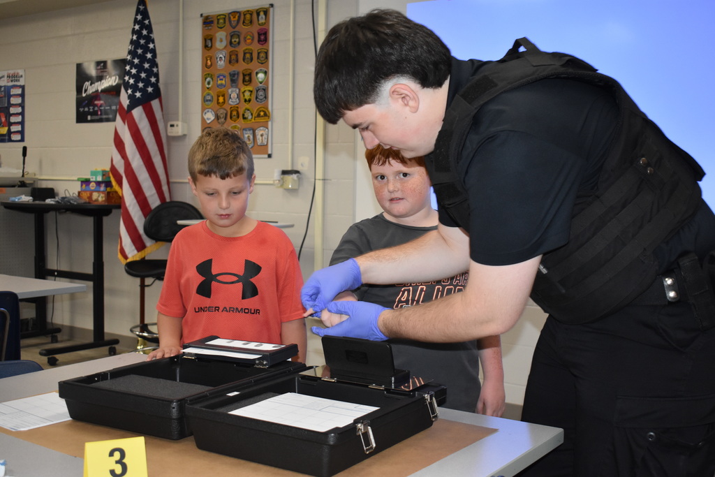 Two students learn about fingerprinting