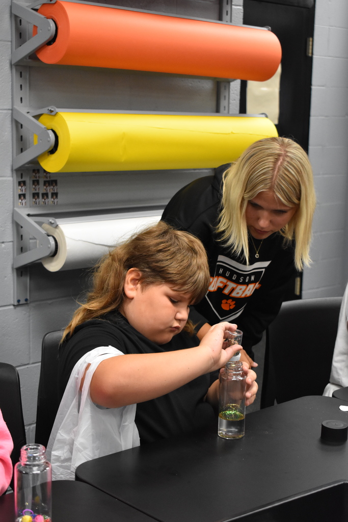 Student creates a project while a student helper looks on
