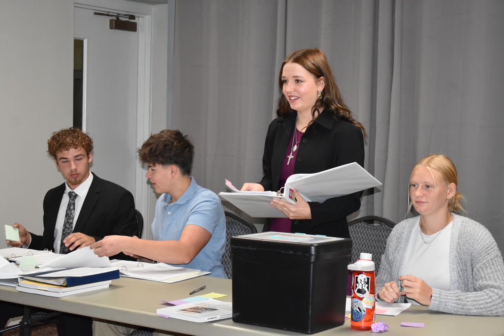 Student presents her argument while other students look on