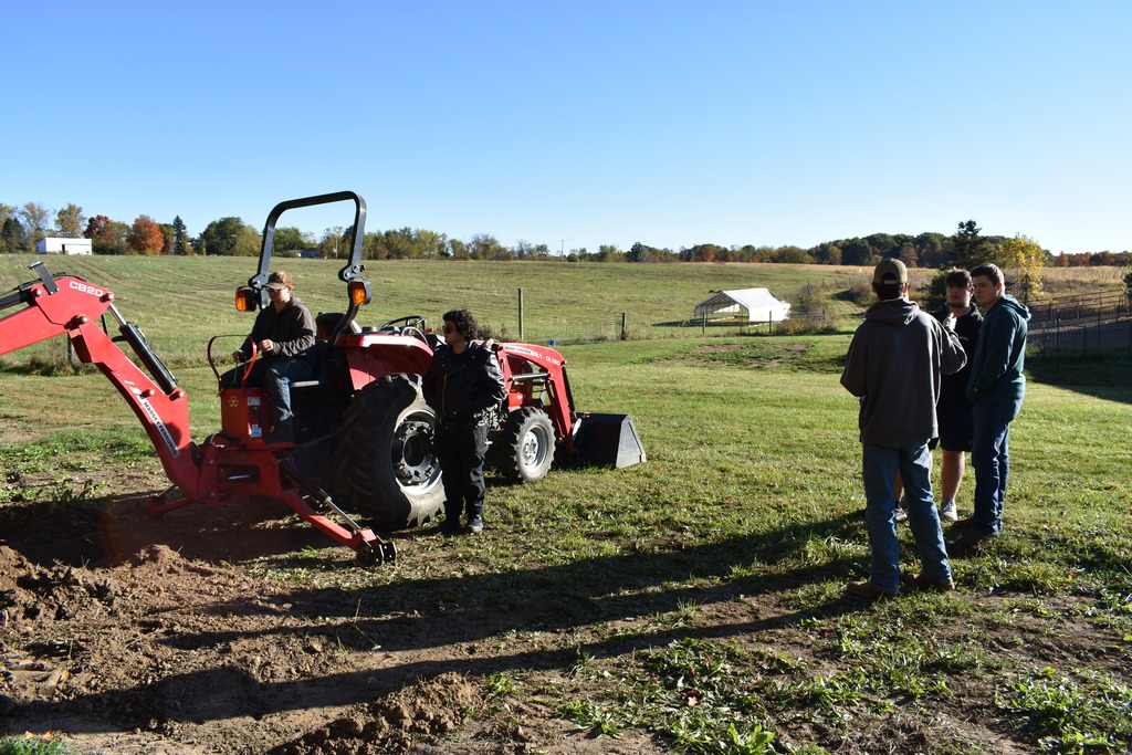 Students learning about equipment at the farm
