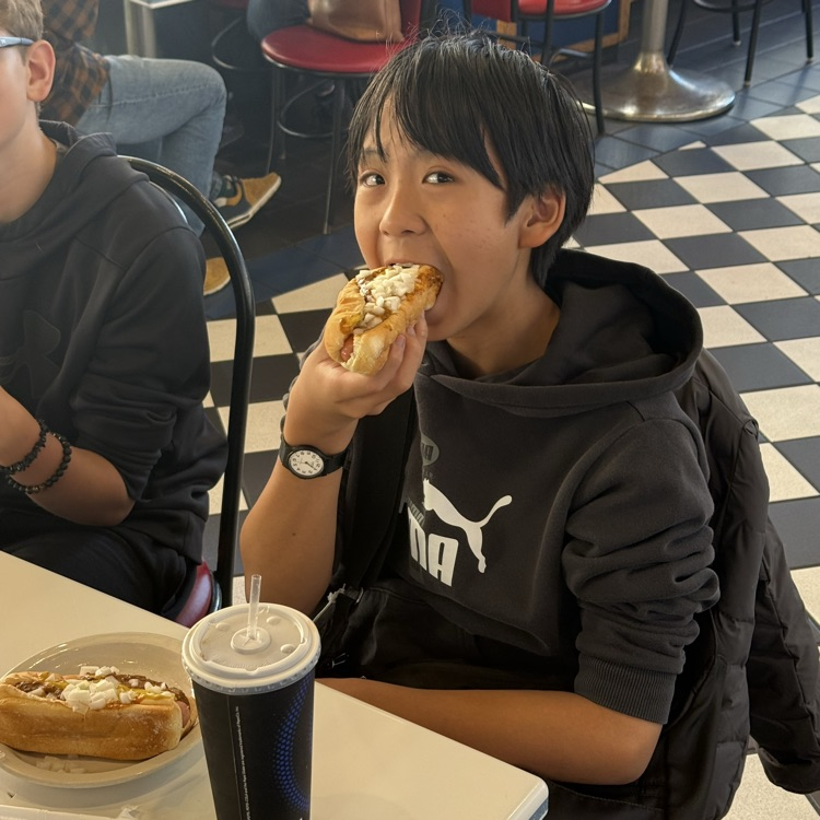 student eating a famous coney dog 