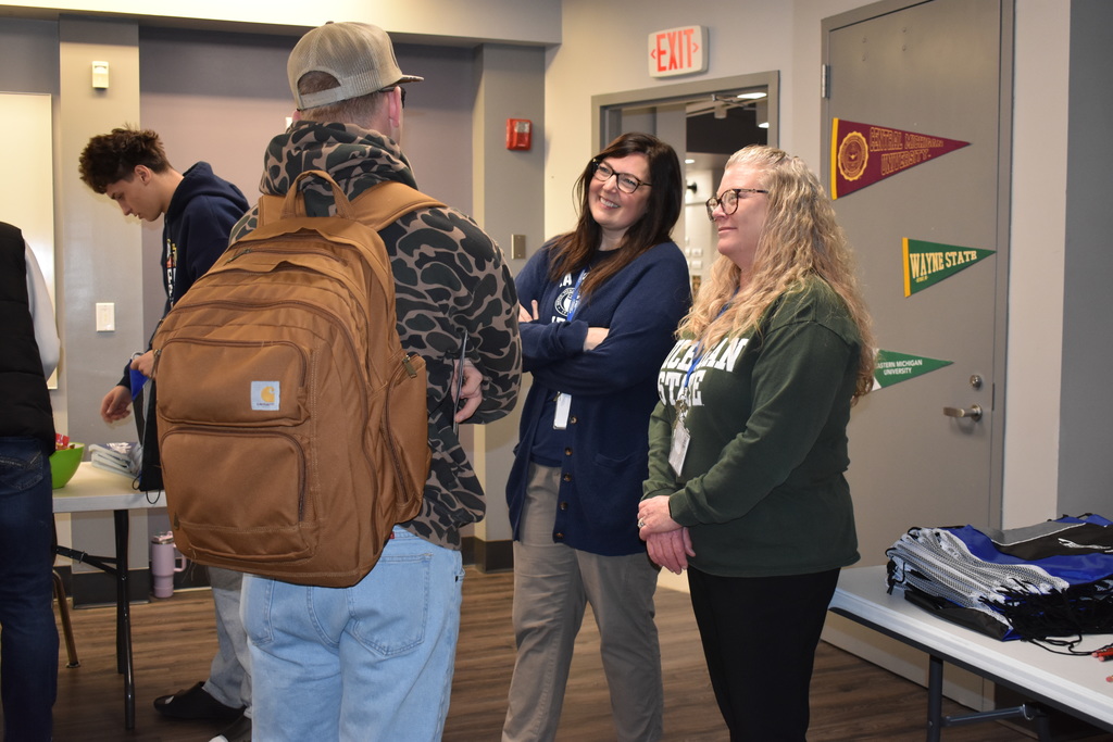 two counselors chat with a student