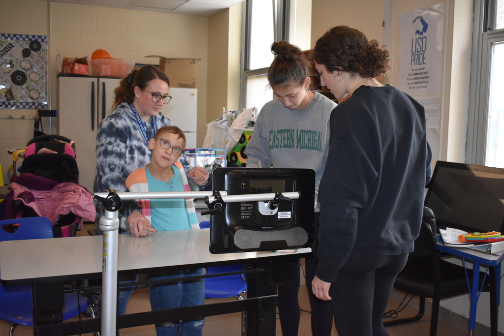 Student volunteers helping a student with his pumpkin