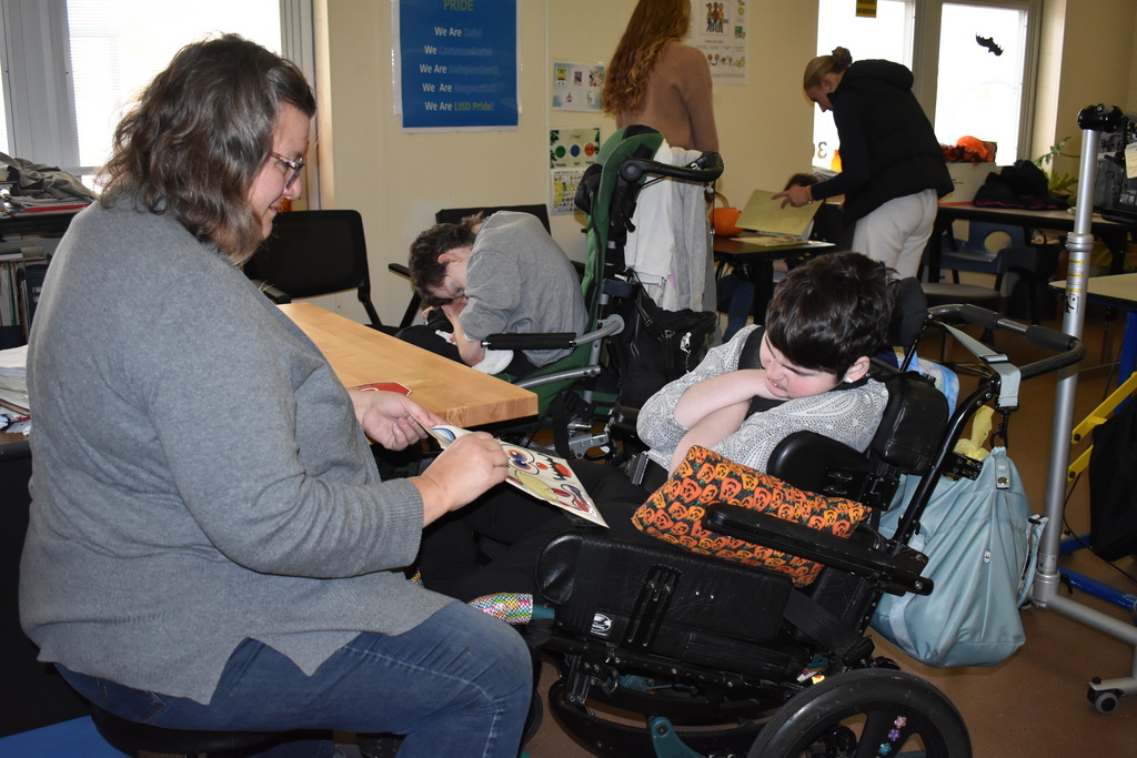 A teacher helping a student pick a face for the pumpkin