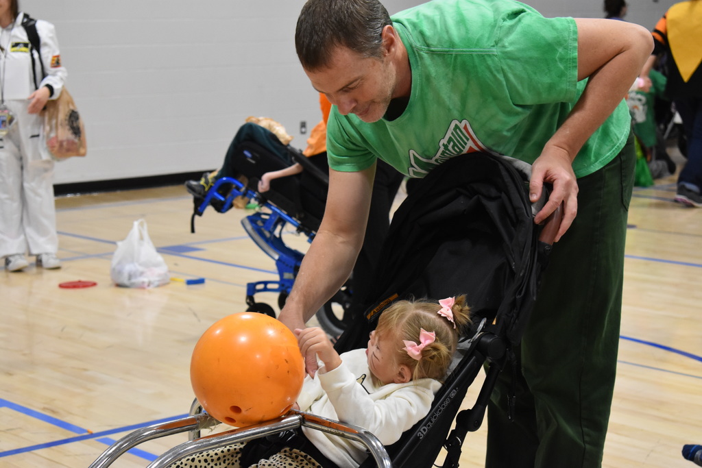 An instructor helps a student bowl