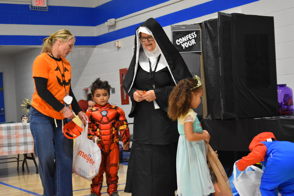 A staff member dressed as a nun engages with a few preschoolers