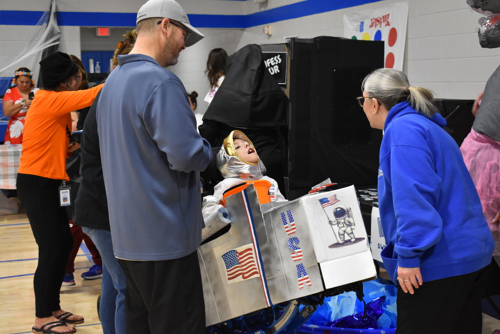 A teacher chats with a student and parents