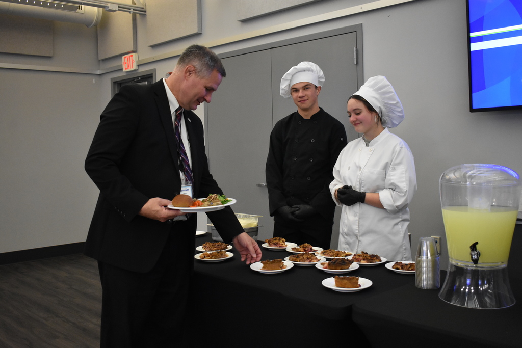 Superintendent Mark Haag getting dessert from TECH Center students