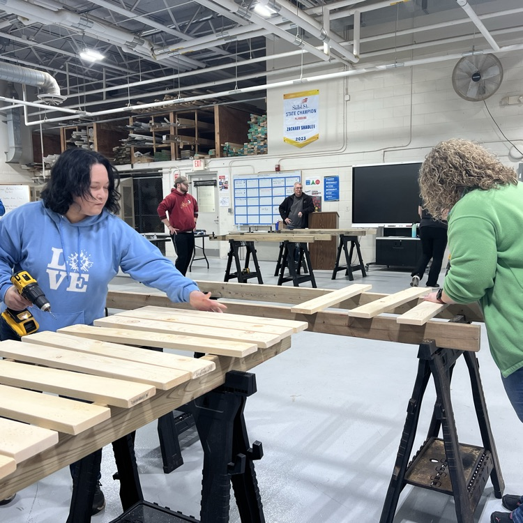 two people assembling a bed