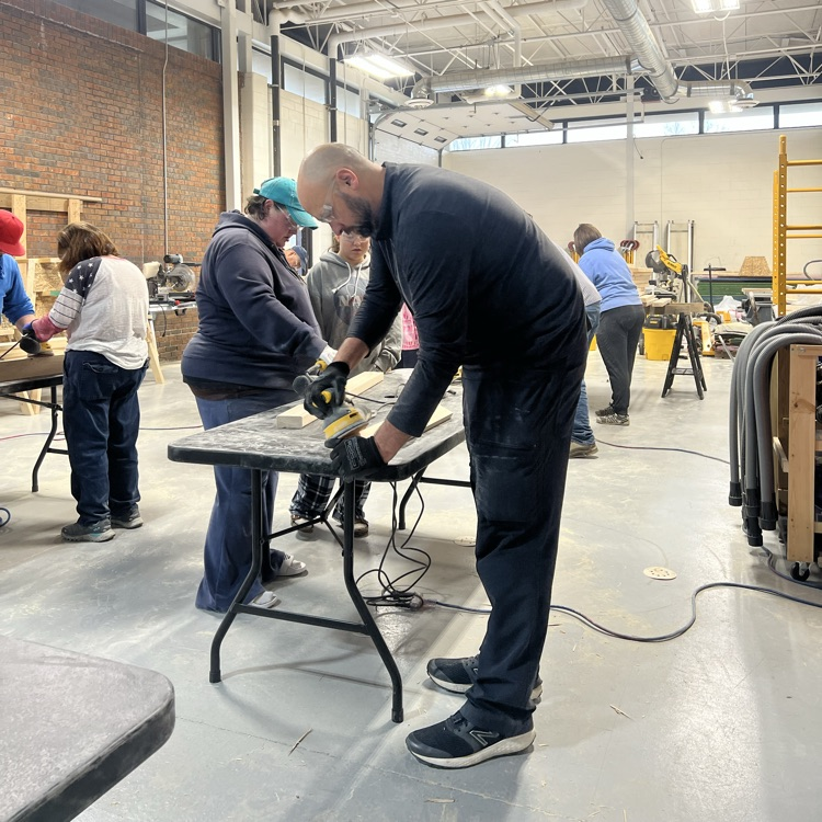 people sanding boards