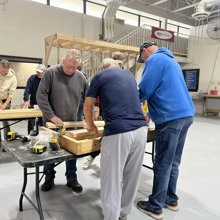 three people assembling a bed