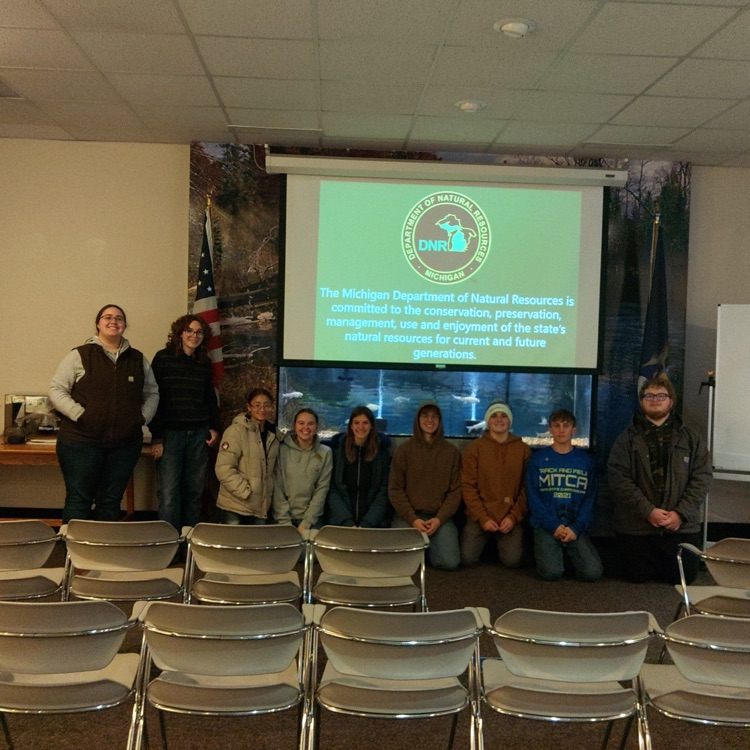 students posing with a DNR screen behind them