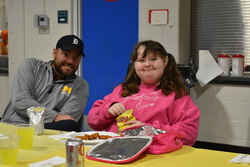 A teacher and student posing with smiles