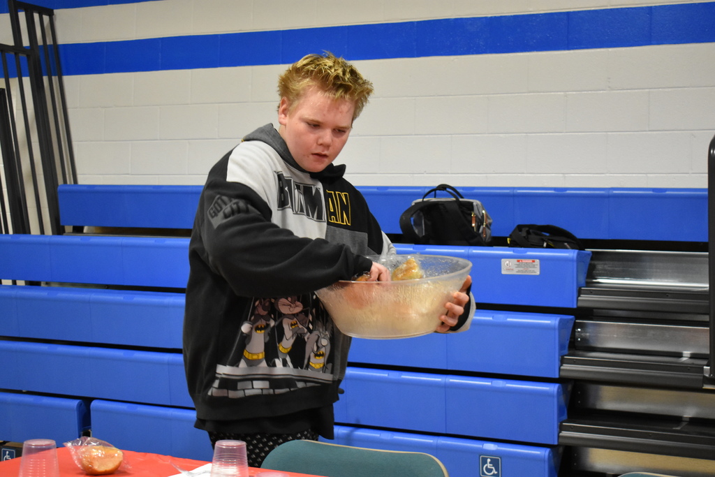 A student passing out dinner rolls