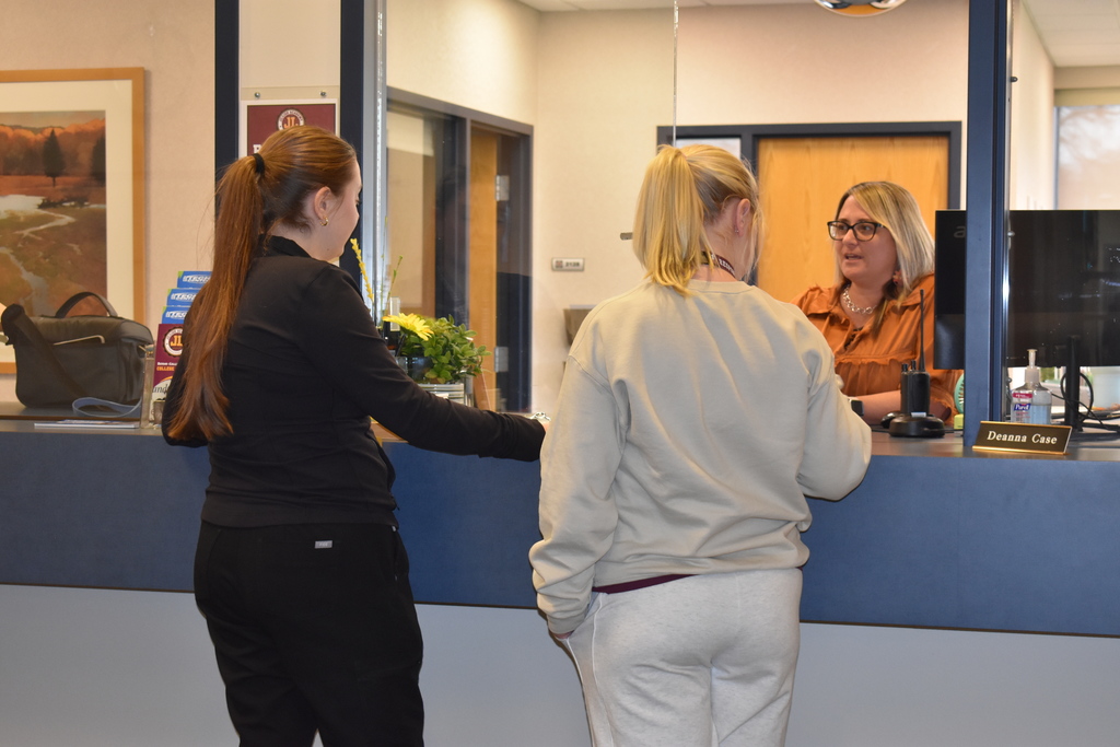 Alum chatting with Deanna at the front office