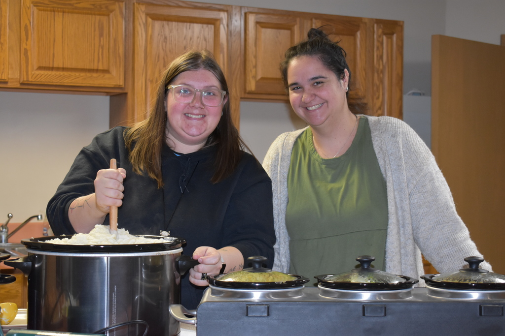 Two staff members preparing a meal