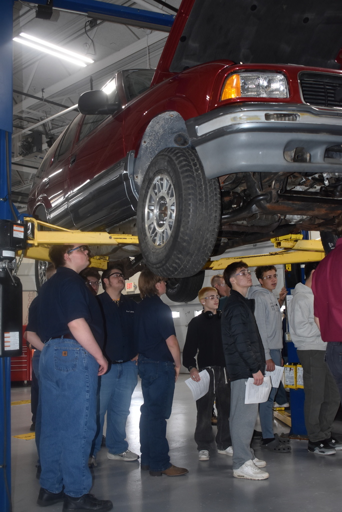 students under a vehicle during the tour