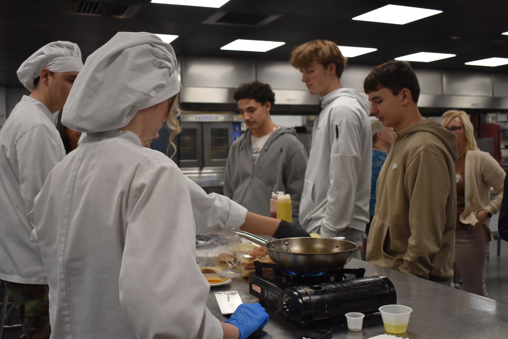 Students learning from culinary and having burgers made for them