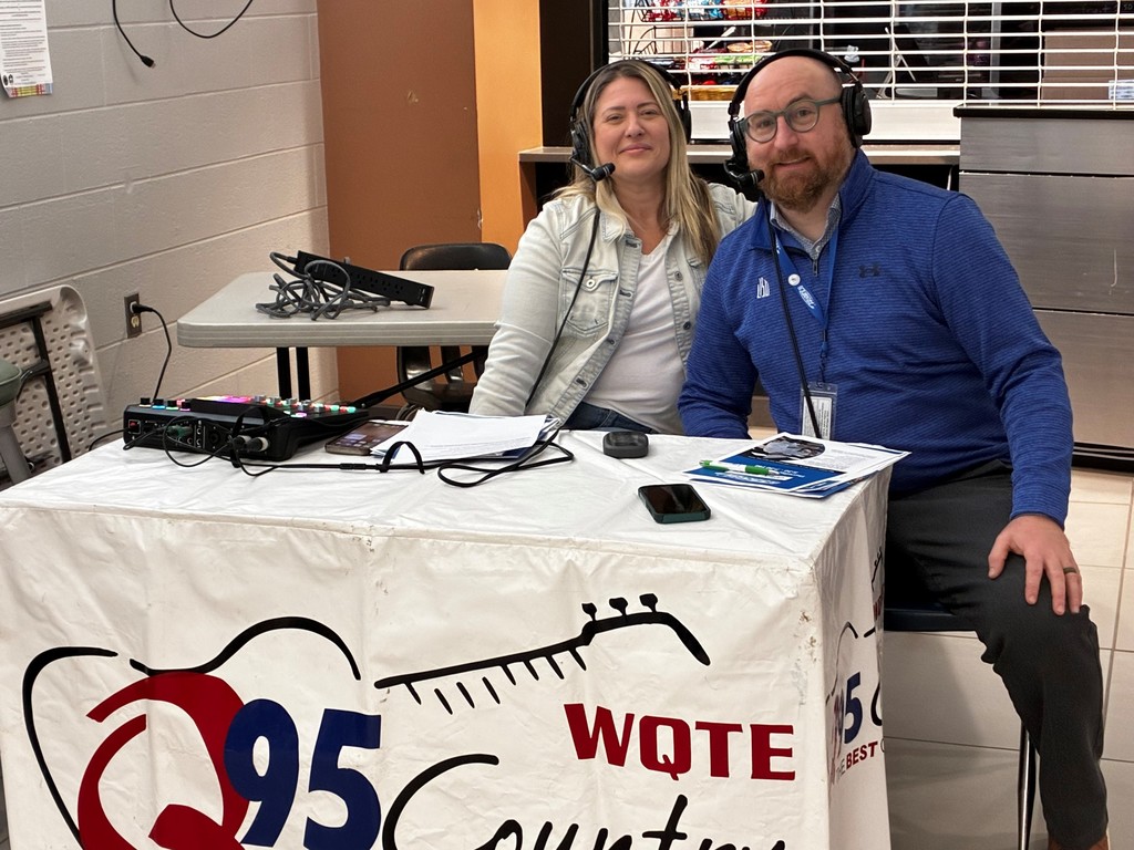 Ben, the Principal, and Shannon from the Q pose for a photo with their headsets on