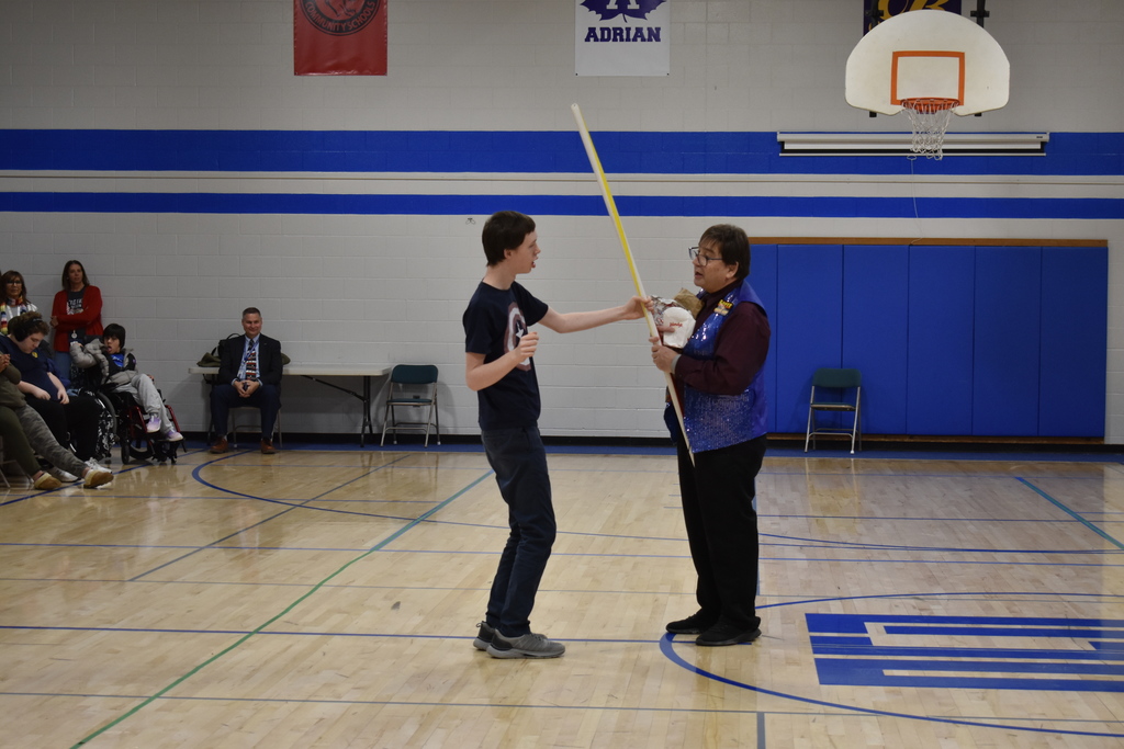 A student engaging with a large straw the magician pulled out of a small bag