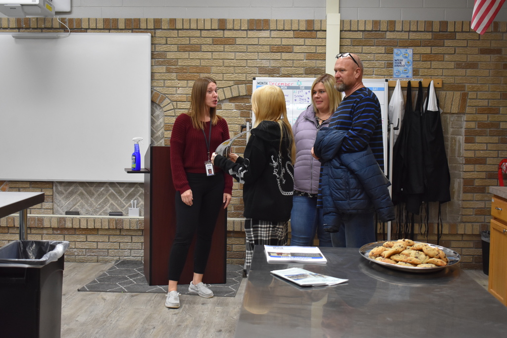 A family touring Hospitality Services and chatting with the instructor