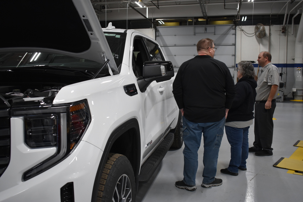 A family touring Auto and looking at a truck