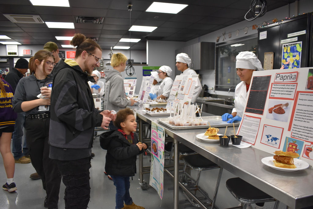 A parent and young child enjoying the culinary program