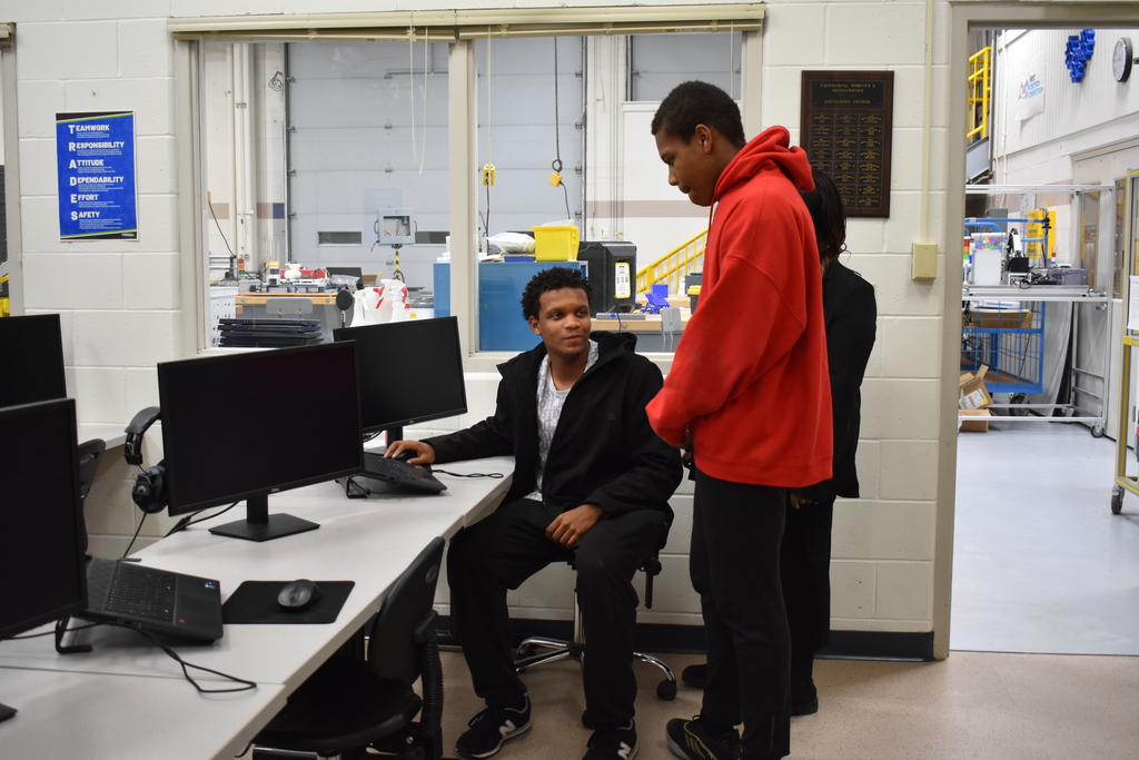 An older sibling exploring Robotics with his brother and mom