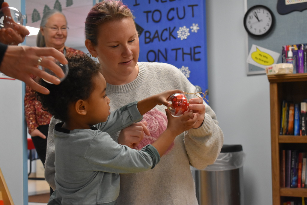 An instructor showing a child an ornament