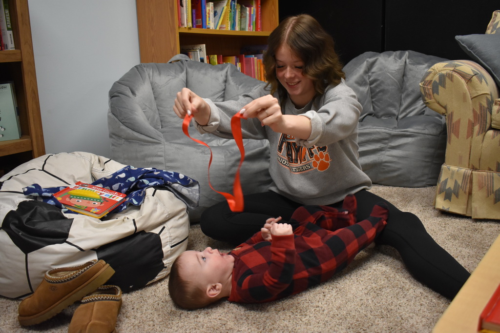 A mom and her son playing with a ribbon