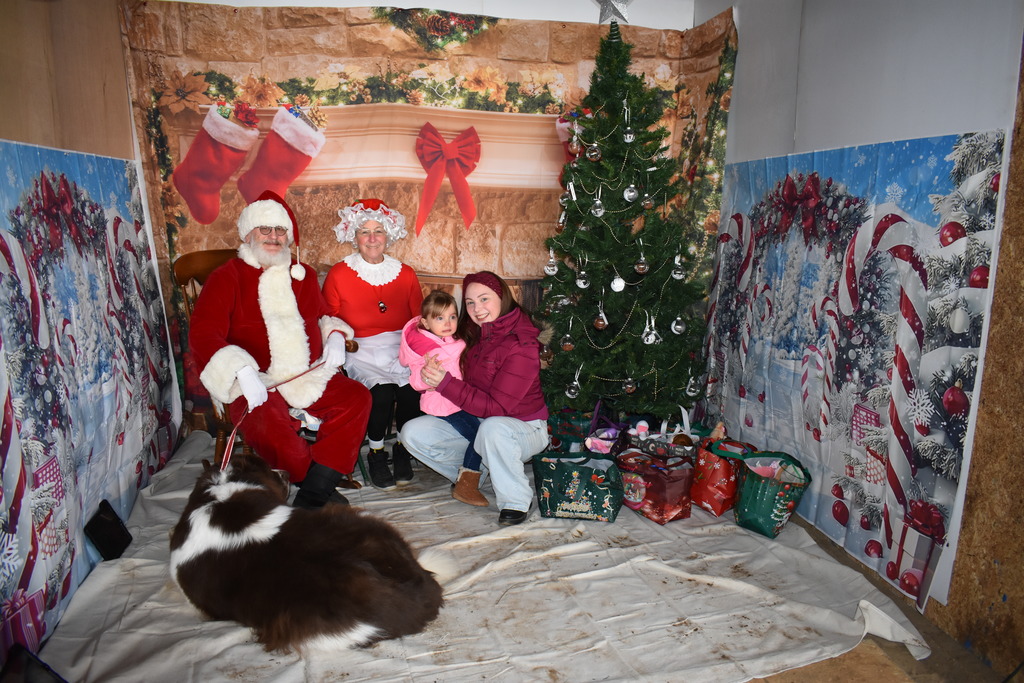 A little girl and her mom with Mr. and Mrs. Claus