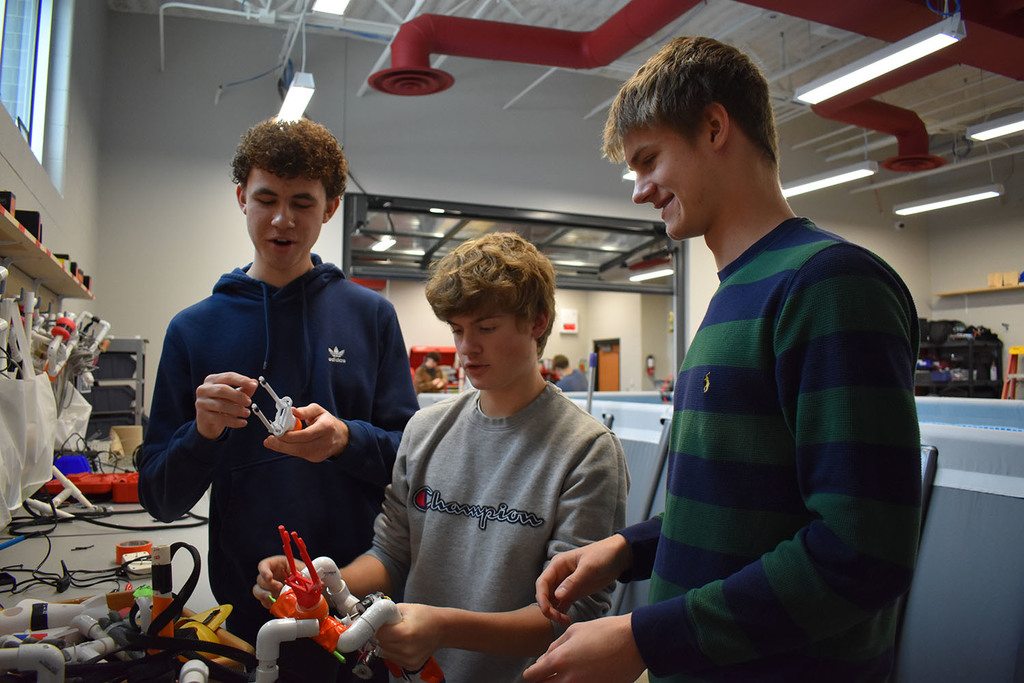 Three students discussing robotics