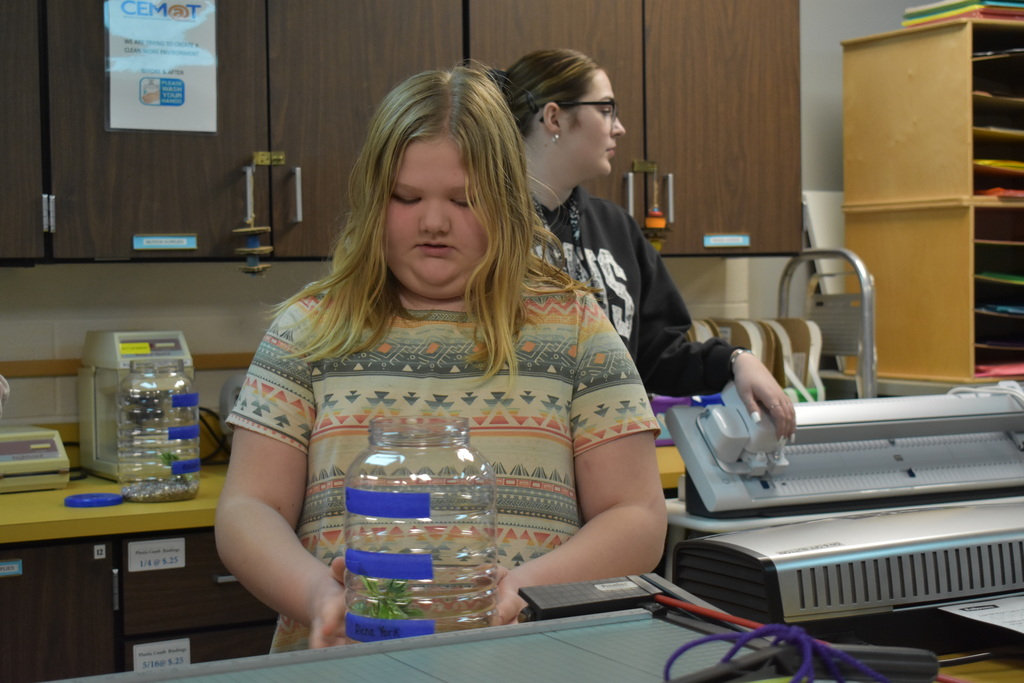 a student inspecting her aquarium