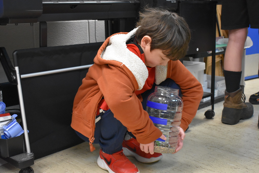 a student sitting with his aquarium he put together